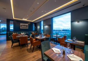 a restaurant with tables and chairs and a large window at The Landing Hotel in Westerham