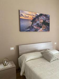 um quarto com uma cama com uma fotografia na parede em Voce 'e notte em SantʼAntonio Abate