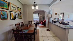 a kitchen and dining room with a table and a counter at Plum Cottage in Balgowan