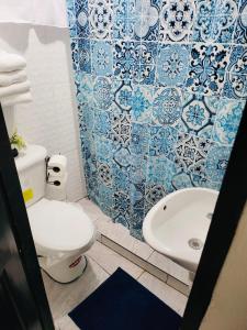 a blue and white bathroom with a toilet and a sink at Residencial Lassonde Guest House in David
