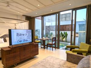 a living room with a television on a wooden entertainment center at Cape House in Amritsar