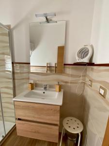 uma casa de banho com um lavatório, um espelho e um banco em Voce 'e notte em SantʼAntonio Abate