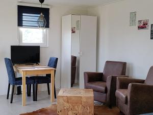 a living room with a table and chairs and a television at De Weelen in Lutjebroek