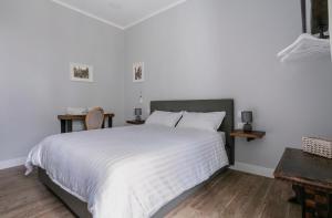 sypialnia z dużym białym łóżkiem i dwoma stołami w obiekcie Casaletto's Suites w mieście Riano