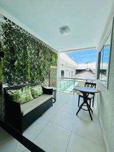 ein Wohnzimmer mit einem Sofa und einem Tisch auf dem Balkon in der Unterkunft Hotel Antiga Roma in Belém