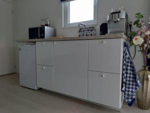 a kitchen with white cabinets and a counter top at De Weelen in Lutjebroek