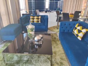 een woonkamer met twee blauwe banken en een glazen tafel bij Casalos Hotel & Spa in Huancayo