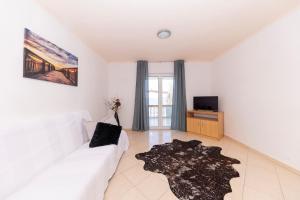a living room with a white couch and a television at Apartments Seaside in Bibinje