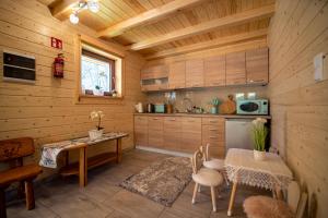 a kitchen with a table in a wooden cabin at Domek Nad Stawem II in Limanowa