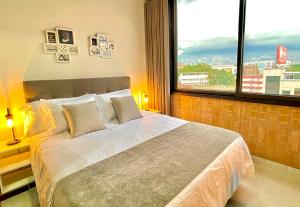 a bedroom with a large bed with a large window at APARTAMENTOS EN LAURELES, MEDELLÍN in Medellín