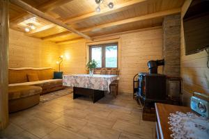 a room with a table and a stove in a room at Domek Nad Stawem II in Limanowa