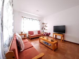 a living room with a couch and a flat screen tv at Txada Hostel in Praia