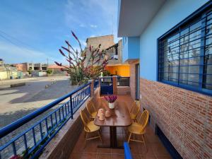 a patio with a table and chairs on a balcony at Txada Hostel in Praia