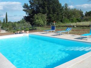 a swimming pool with two blue chairs next to it at CASA VACANZE L'OLIVO in Lubriano