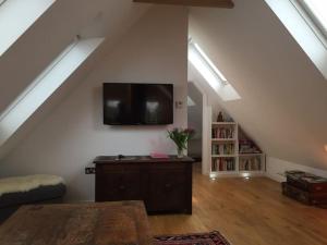 a living room with a flat screen tv on the wall at The Loft in Brockenhurst