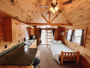 ein Schlafzimmer mit einem Bett in einer Holzhütte in der Unterkunft Deluxe Cabin7 Within Campground in Mifflinburg