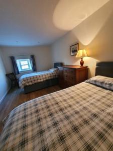 a bedroom with two beds and a table with a lamp at Bandar Cottage, farm cottage, close to Narberth, Pembrokeshire in Narberth