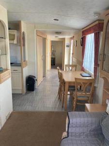 a living room with a table and a kitchen at Sunshine Lodge-by-Saltfleet - 221 Kingfisher Gardens in Saltfleet