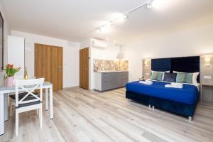 a bedroom with a bed and a table and a kitchen at Polanka Apartamenty in Niechorze