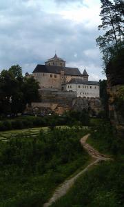 un gran castillo en la cima de una colina con un camino de tierra en Glamping Challet Slunečno Český ráj, en Dobšín