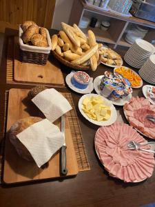 una mesa cubierta con platos de comida y pan en Glamping Challet Slunečno Český ráj, en Dobšín