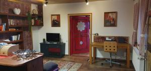 um quarto com uma secretária e uma porta vermelha em Ferienwohnung Vogl mit Klimaanlage und Kaminofen em Viechtach