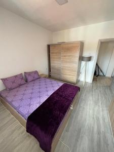 a bedroom with a purple bed in a room at Viktorija's Apartment in Gevgelija