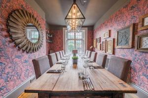 a dining room with a long wooden table and chairs at The Ship At Dunwich in Dunwich