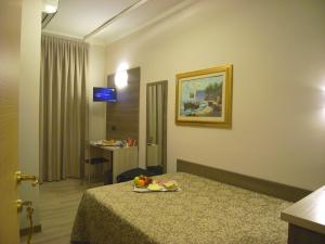 a hotel room with a bed with a plate of fruit on it at Hotel Siena in Milan