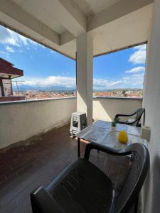 a table and chairs on a balcony with a view at Viktorija's Apartment in Gevgelija