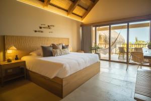 um quarto com uma cama grande e uma varanda em Hotel Aimarawa em San Antero