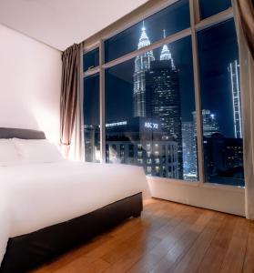 um quarto com uma grande janela com um horizonte da cidade em Soho Suites KLCC by Alucard's Cat em Kuala Lumpur