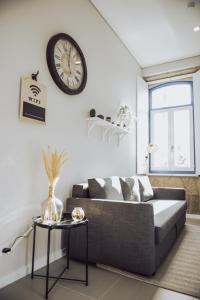 uma sala de estar com um sofá e um relógio na parede em Estação Ferroviária de Lourido em Celorico de Basto
