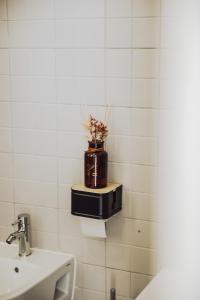 a bathroom with a sink and a vase with flowers in it at Estação Ferroviária de Lourido in Celorico de Basto