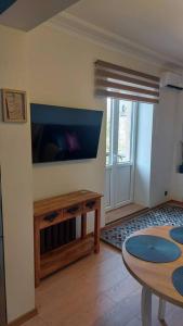uma sala de estar com uma mesa e uma televisão de ecrã plano em Luxury Stable 1 em Rezekne