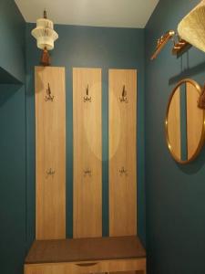 a bathroom with four wooden hangers and a mirror at Luxury Stable 1 in Rēzekne