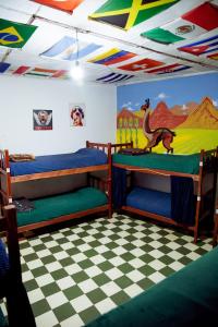 a room with two bunk beds and a checkered floor at Apapacho Hostel in Tilcara