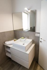 een badkamer met een witte wastafel en een spiegel bij Ca’ del Riccio verde in Bra