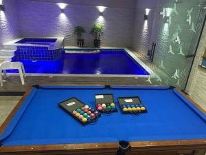 a pool table with two billiard balls on it at Piscina com ofurô/Churrasqueira/Sinuca e Ping Pong in Caraguatatuba