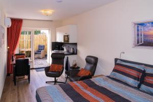 ein Schlafzimmer mit einem Bett und zwei Stühlen darin in der Unterkunft De Sprink - Luxe Kamer - Strand & Zee in Zoutelande