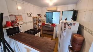 a kitchen with a refrigerator and a counter top at Villa Guará - Vila de São Jorge in Alto Paraíso de Goiás