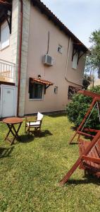 a house with a table and a bench in the yard at The Cozy Yard in Nea Potidaea