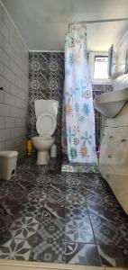 a bathroom with a toilet and a shower curtain at The Cozy Yard in Nea Potidaea