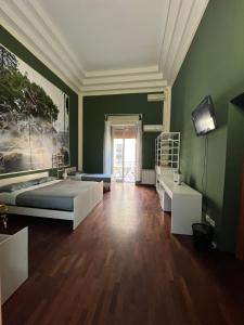 uma sala verde com uma cama e uma televisão em Umberto Street em Catânia