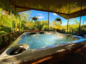 a jacuzzi tub sitting on top of a porch at Bungalows Yakari Grei in San Ramón