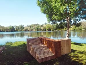 un quai en bois assis sur le côté d'un lac dans l'établissement Hôtel L'ile Du Saussay, à Itteville