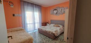 una camera da letto con pareti arancioni, un letto e una finestra di Andrea affittacamere e B&B a Solignano Nuovo