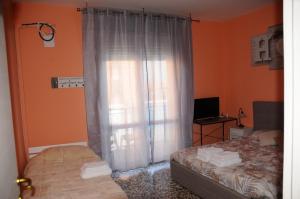 a bedroom with a bed and a window with curtains at Andrea affittacamere e B&B in Solignano Nuovo