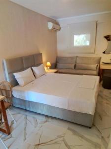 sypialnia z dużym łóżkiem i kanapą w obiekcie Kallikratia Suites w miejscowości Nea Kallikratia