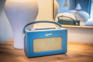 une petite radio bleue assise au-dessus d'une table dans l'établissement The Crown Inn, à Stoke-by-Nayland